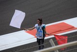 Grand prix F1 commissaire de piste agite drapeaux rouge et blanc fin de course Circuit Yas Marina Abu Dhabi Emirats Arabes Unis