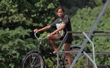 jeune fille et son vélo sur la passerelle de tehaupo polynésie francaise