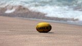 Ballon de rugby jaune Leslie sur une plage Néo-Zélandaise