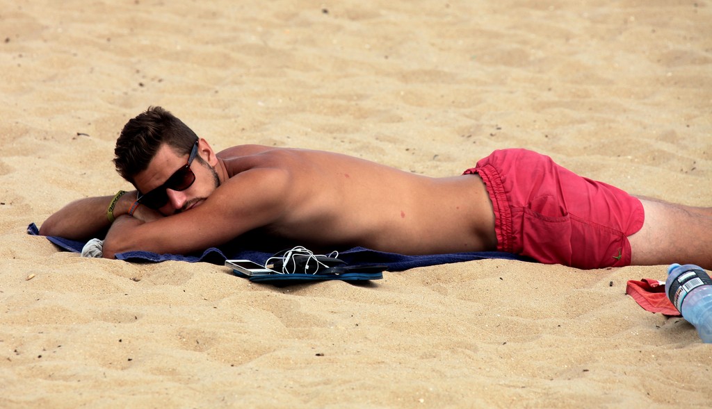 Young men at the beach sunbath Sunglasses Melbourne Australia